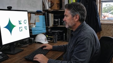 Construction professional at computer using AI design software with digital blueprint overlay in a jobsite office. 