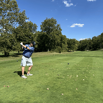 A golfer is mid-swing at ConstructConnect’s Sixth Annual Golf Scramble, benefitting the Ronald McDonald House Charities