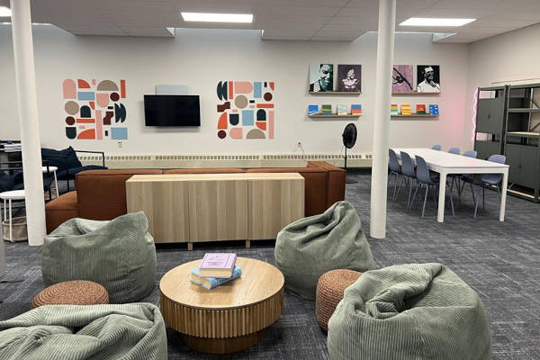 Modern lounge with bean bags, a TV, art on the wall, and collaborative seating.