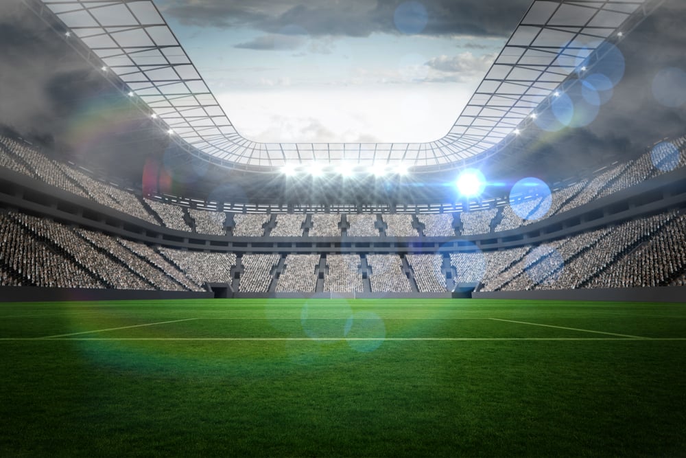 Large football stadium with lights under big sky