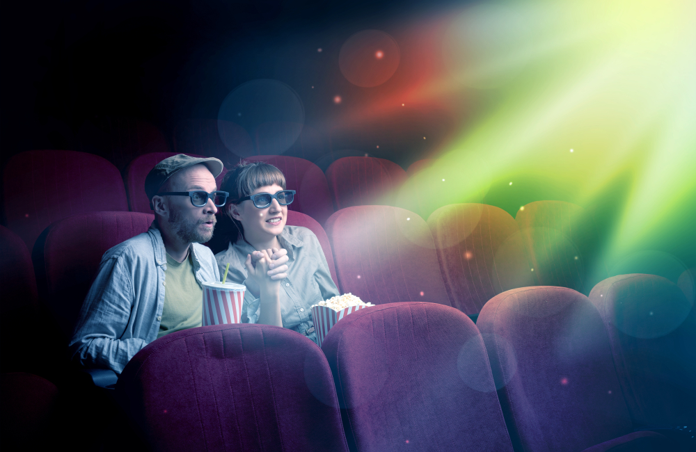 a couple watches a movie in a theater with ribbons of light arcing across the image 