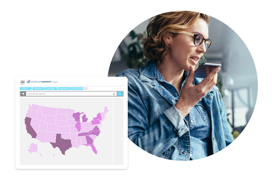 A smiling office or project manager in the commercial construction industry sits at a desk, looking at their computer, while holding a phone up to their mouth. They appear to be analyzing a small overlaid image, which is a heat map of project leads in various geographical areas across the United States.