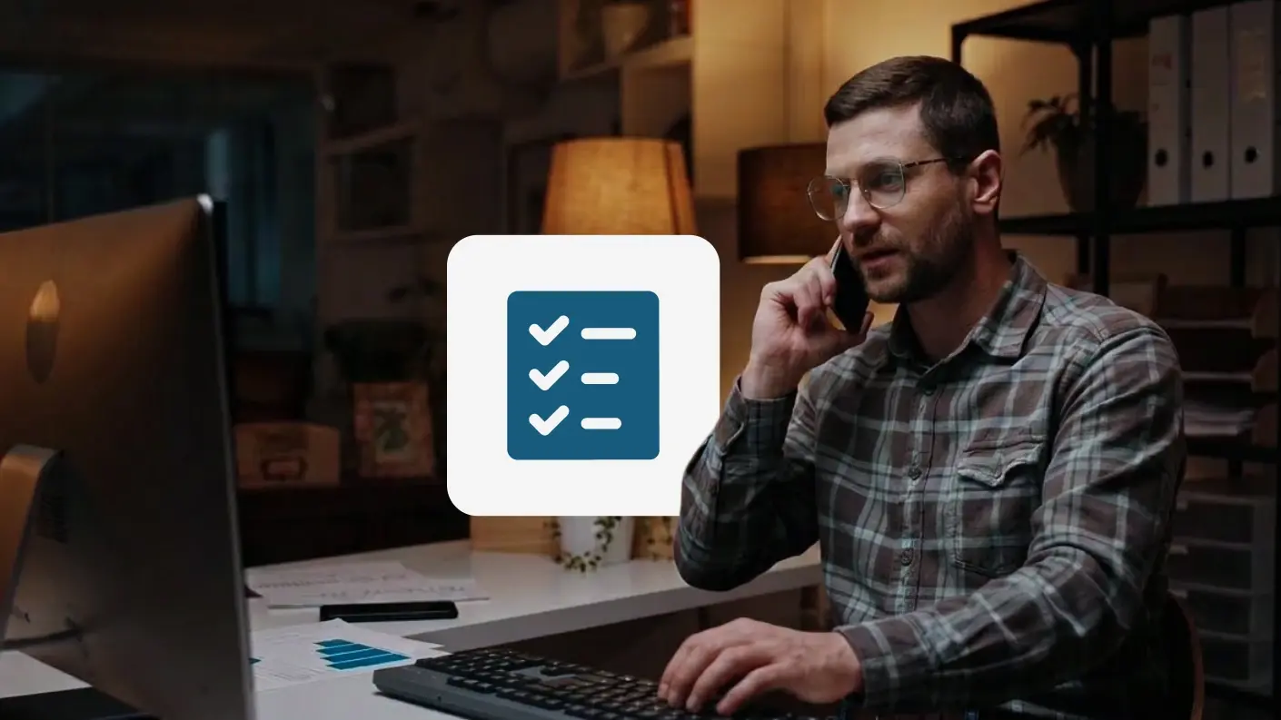 Man sitting at his desk while on the phone and typing on a keyboard