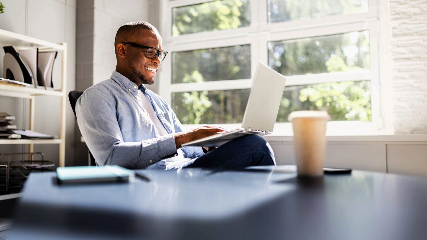 Man smiling while working on laptop