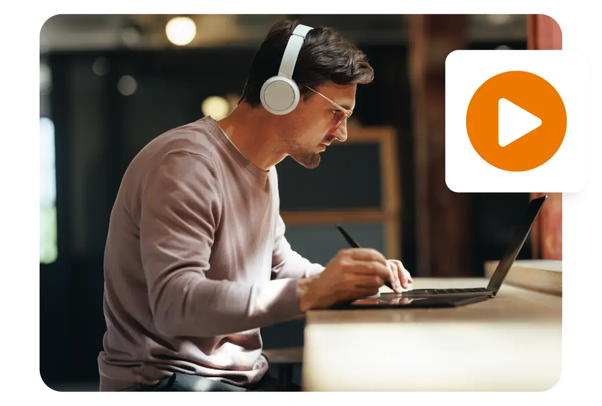 Man wearing headphones and deeply focused while working on a laptop